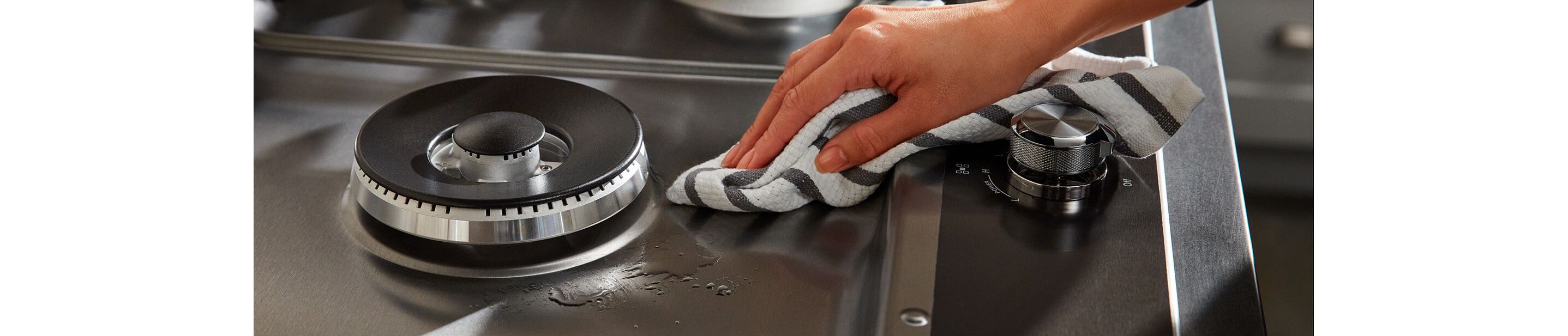 Person wiping a stovetop