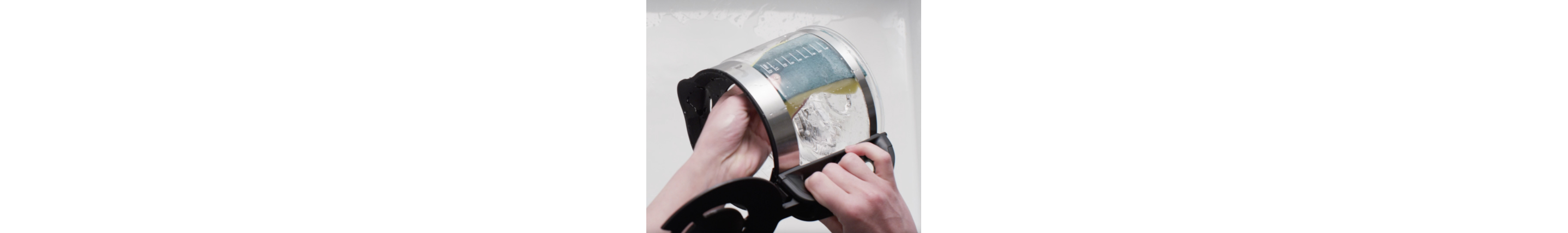 Woman pouring water out of coffee carafe