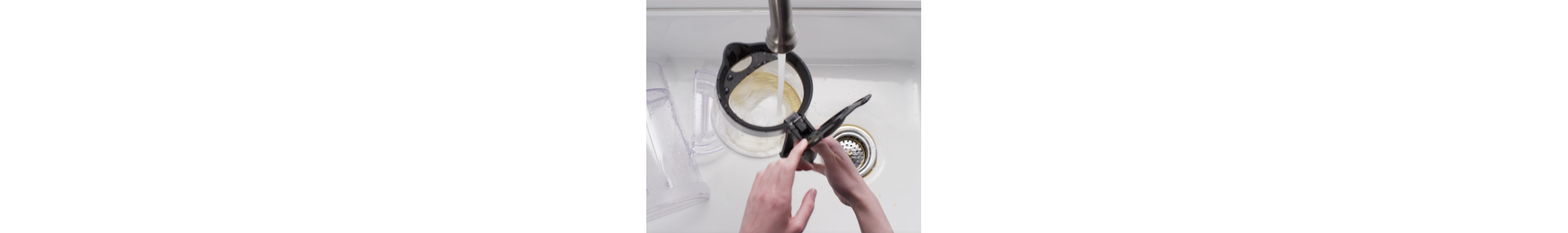 Drip coffee maker parts being cleaned in soapy water