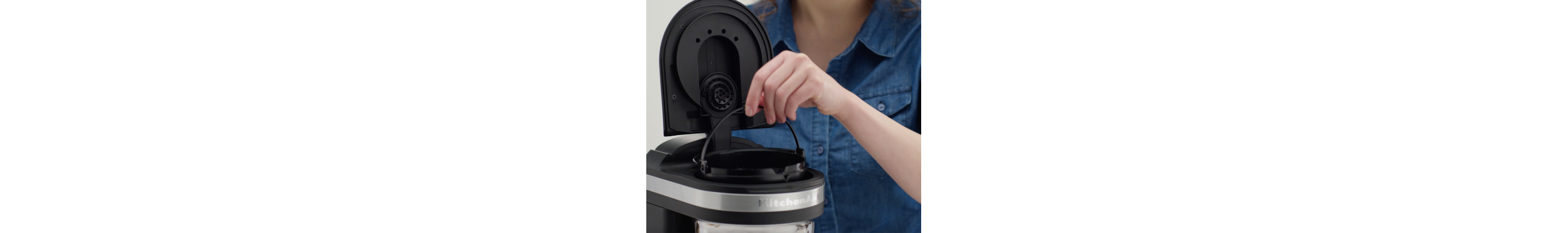 Woman replacing water filter in coffee maker