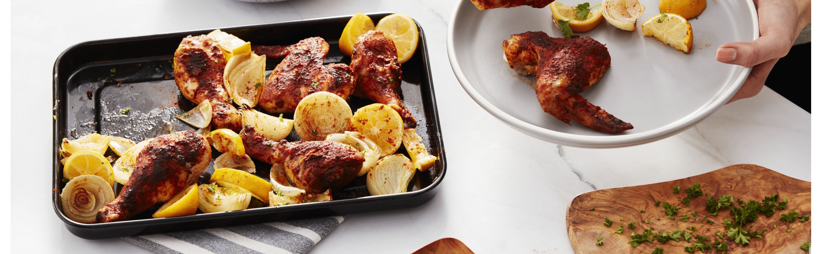 Sheet pan of roasted chicken wings and lemon wedges