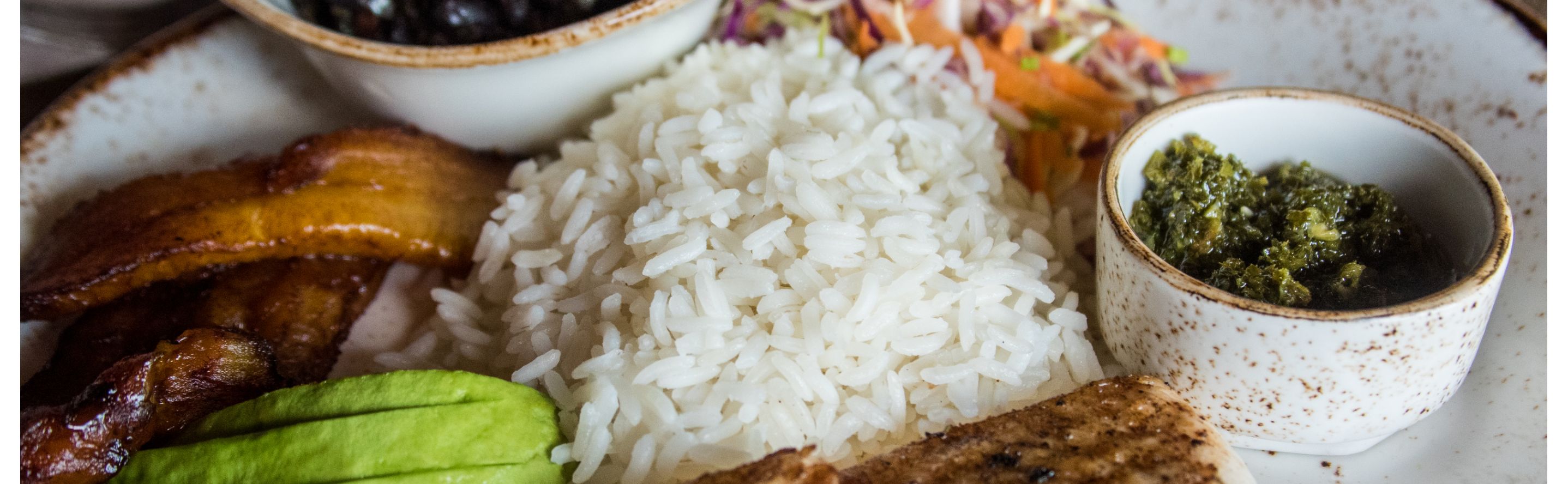 White rice on a place with sauces, vegetables and meat
