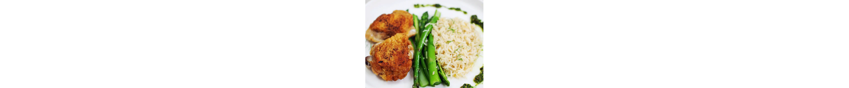 A plate of seasoned rice with asparagus and chicken.