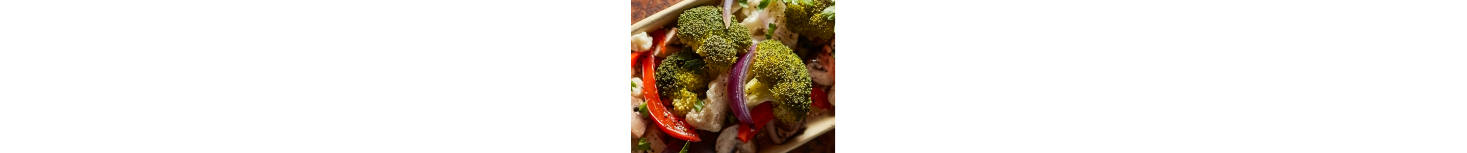 A closeup of fresh vegetables including broccoli, red pepper and red onion.