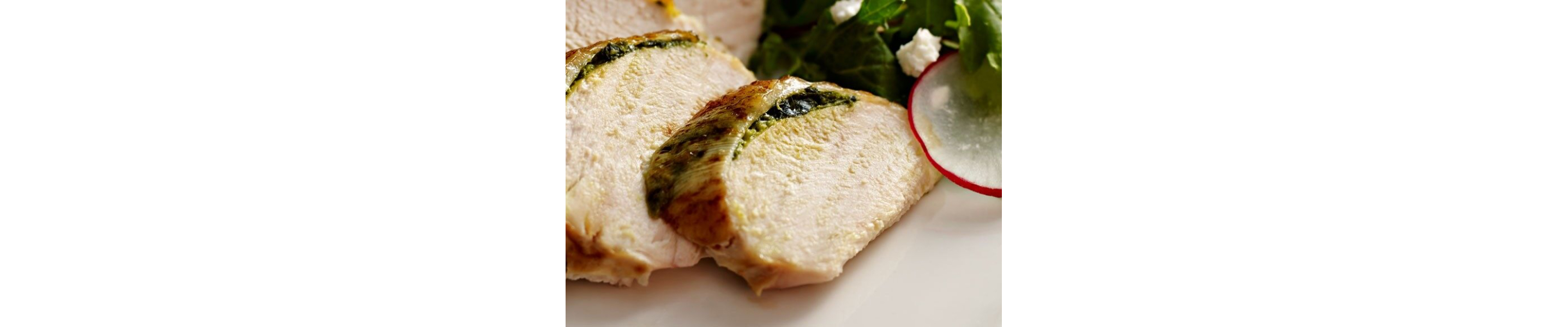 Close-up of a sliced meat dish next to a tossed salad
