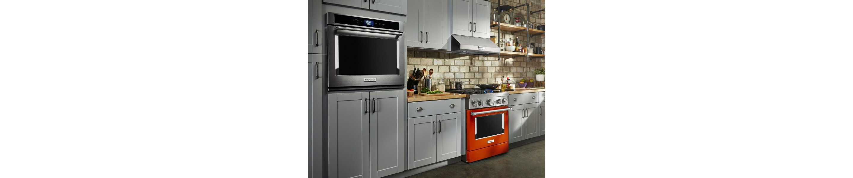 Burnt orange KitchenAid® commercial-style range and KitchenAid® single wall oven in gray cabinetry