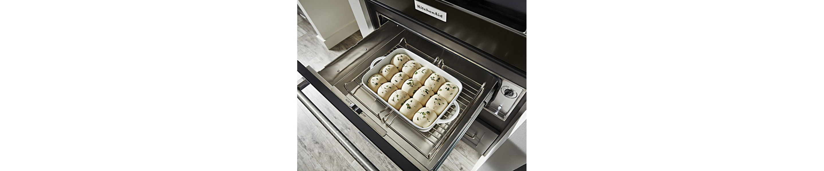 Seasoned roll dough rising in a warming drawer
