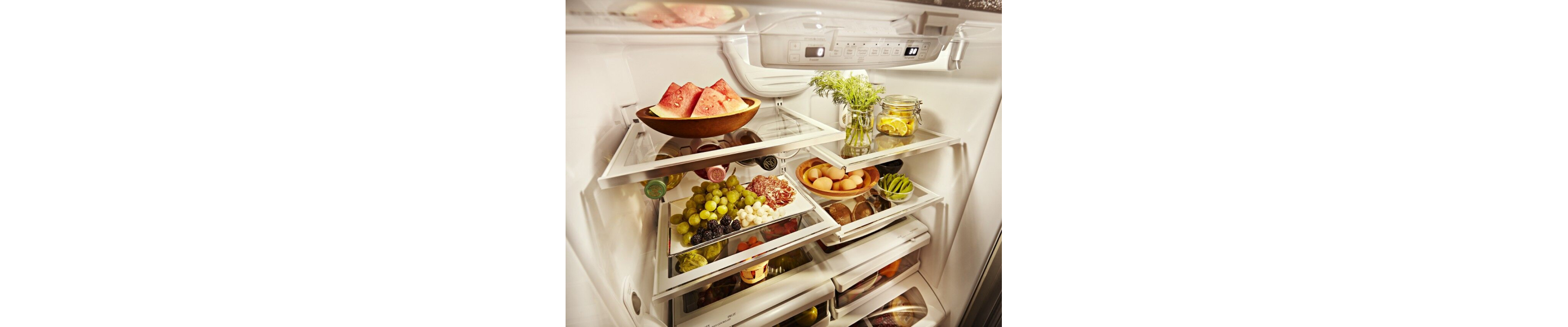 Prepared entrees and appetizers on serving dishes inside a refrigerator