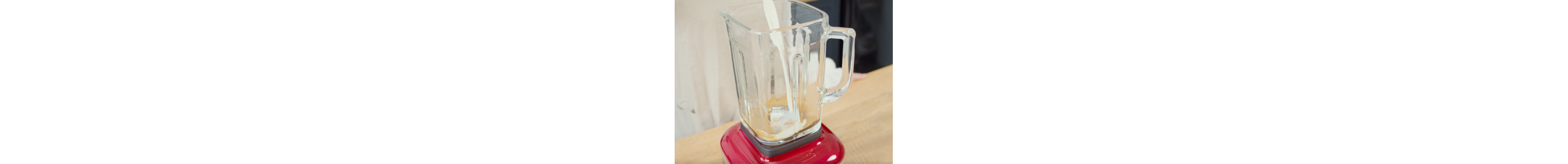 Milk pouring into a red KItchenAid® blender
