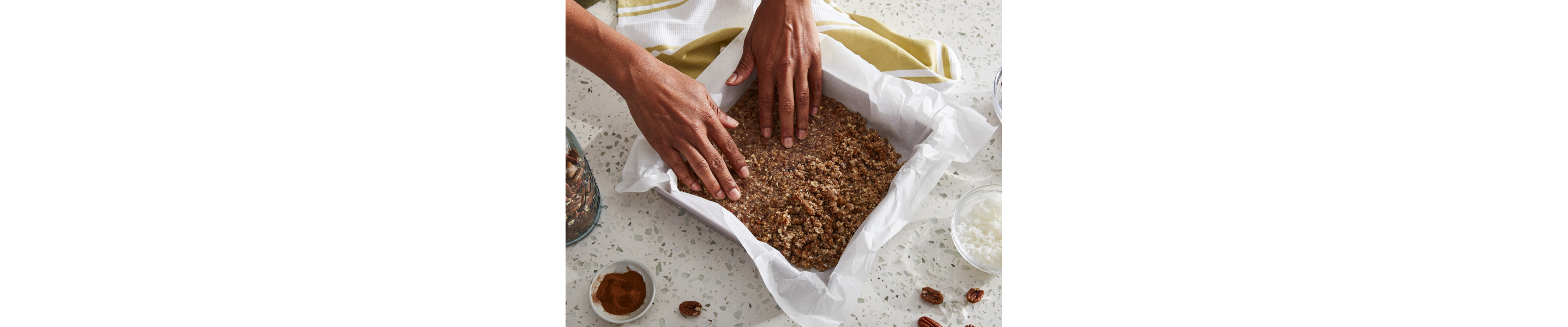 Person forming graham cracker crust in a baking dish