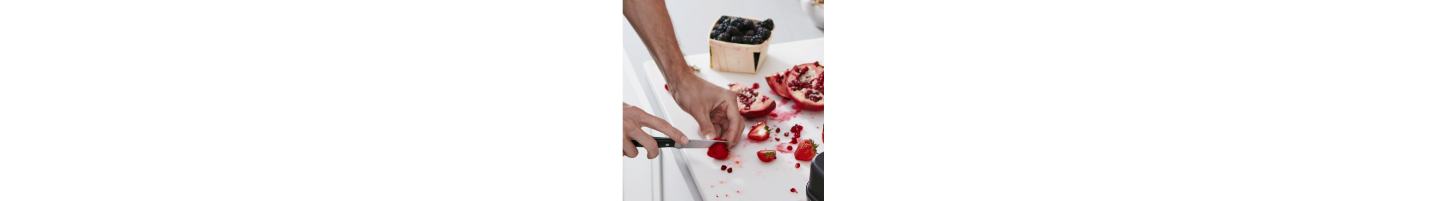 Person slicing fresh fruit on a white cutting board
