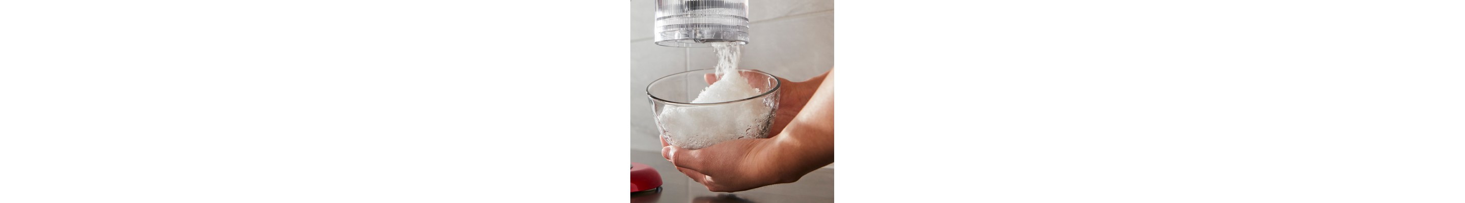 Person using a KitchenAid® stand mixer with shave ice attachment
