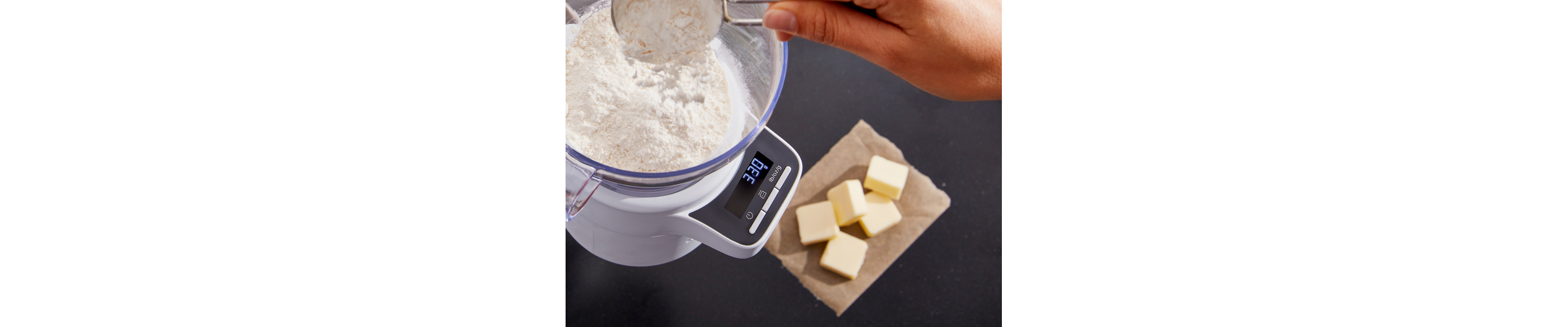 Person adding flour and butter cubes to a bowl