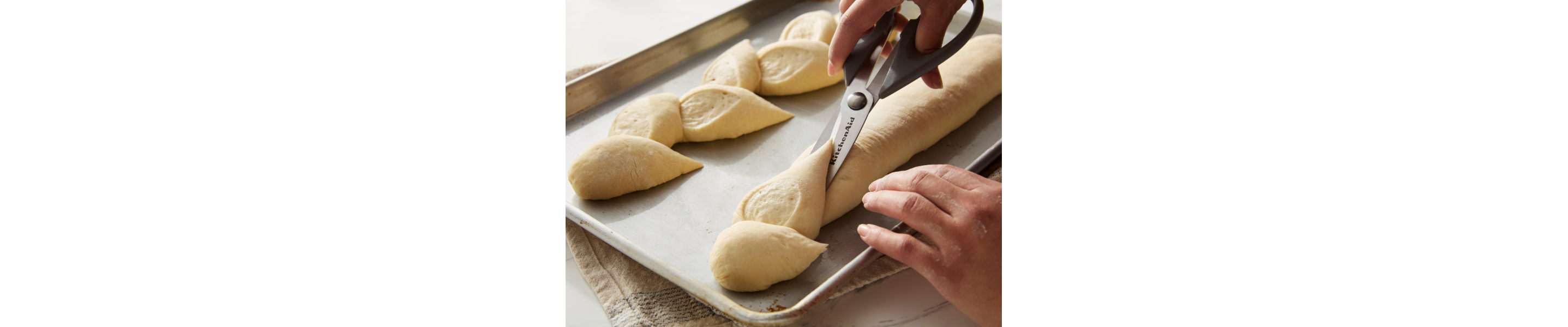 Person cutting dough with scissors