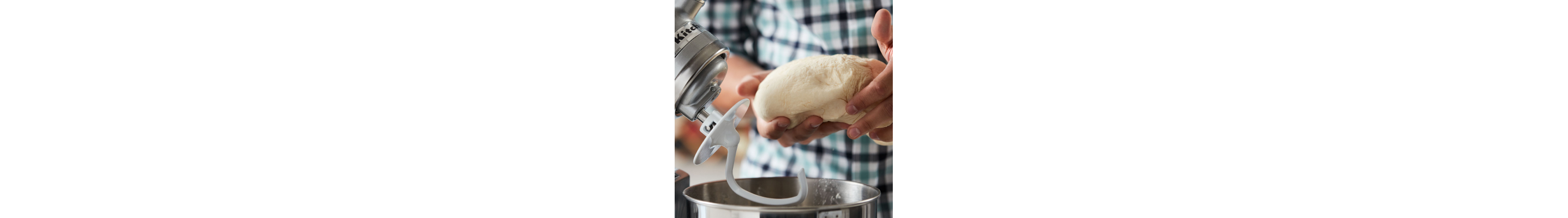 Person removing dough from a stainless steel KitchenAid® stand mixer