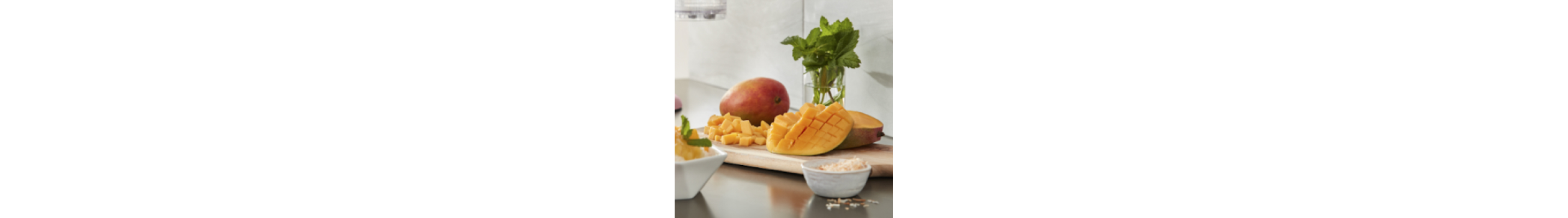 Sliced mangoes and herbs on a cutting board