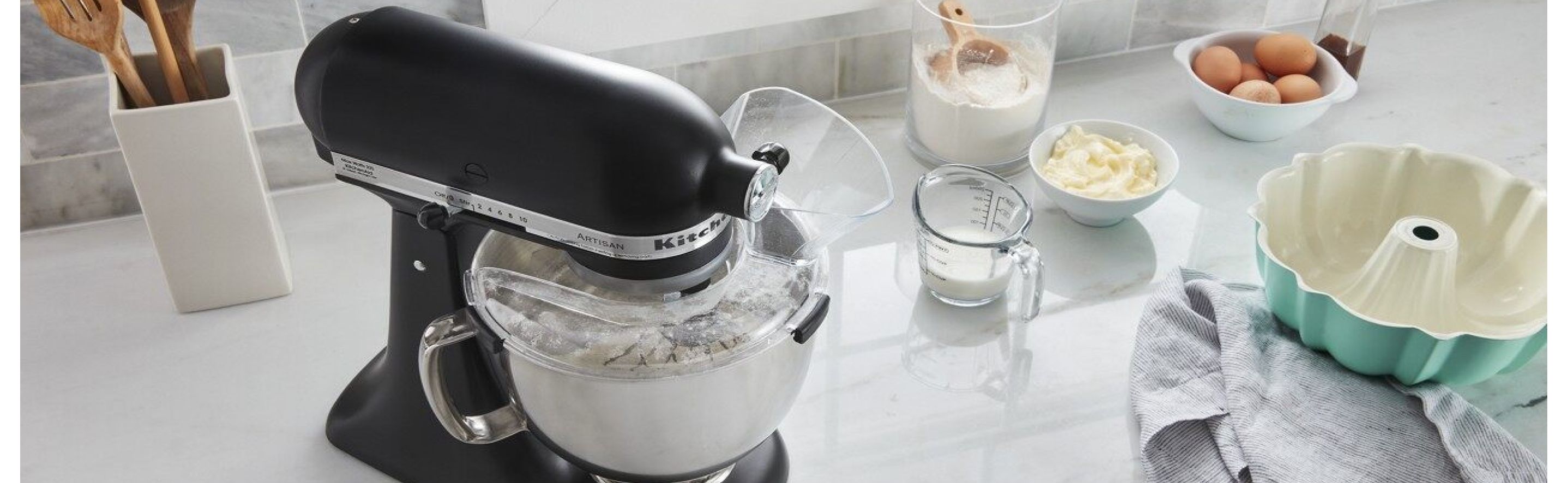A KitchenAid® stand mixer surrounded by baking ingredients
