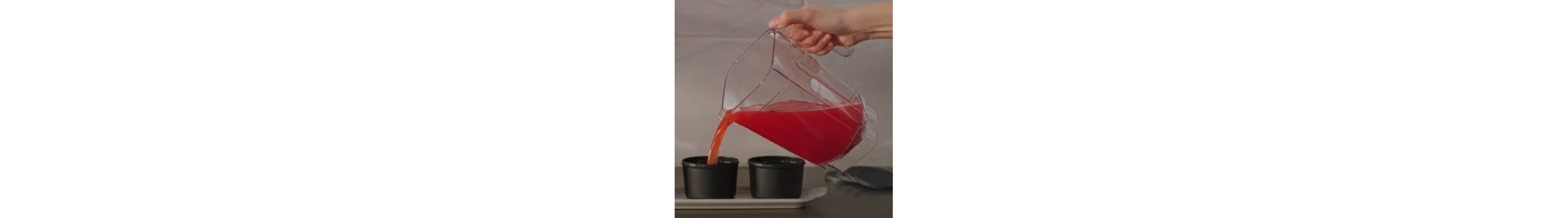 Fruit mixture pouring from a blender into molds