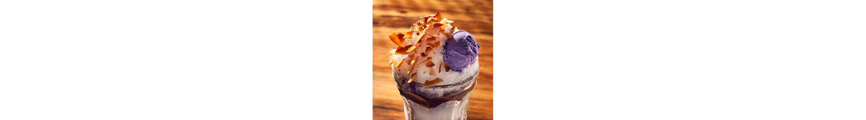A cup of kakigori topped with purple ice cream.