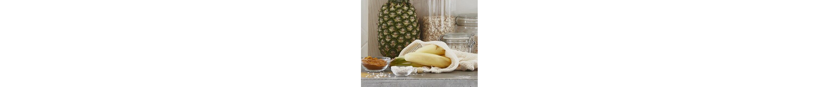 A pineapple and bananas on a kitchen counter