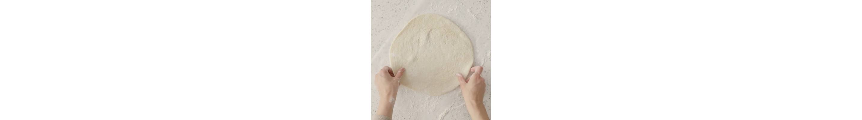 Homemade pizza dough on a floured surface
