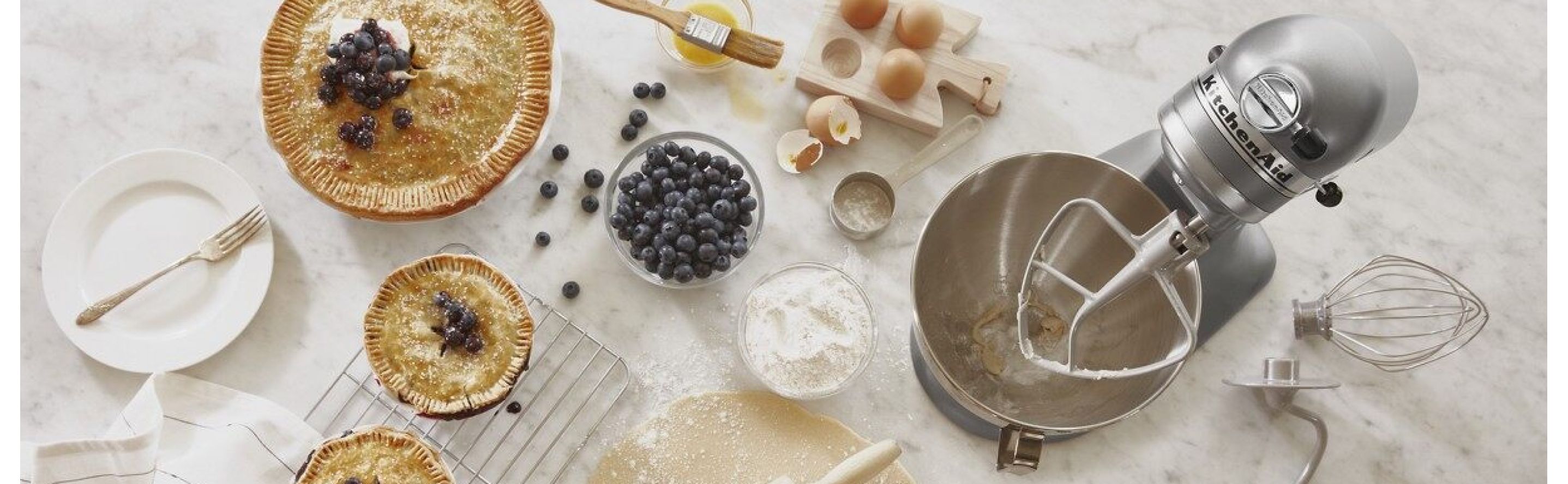 KitchenAid® stand mixer with pies and pastry ingredients