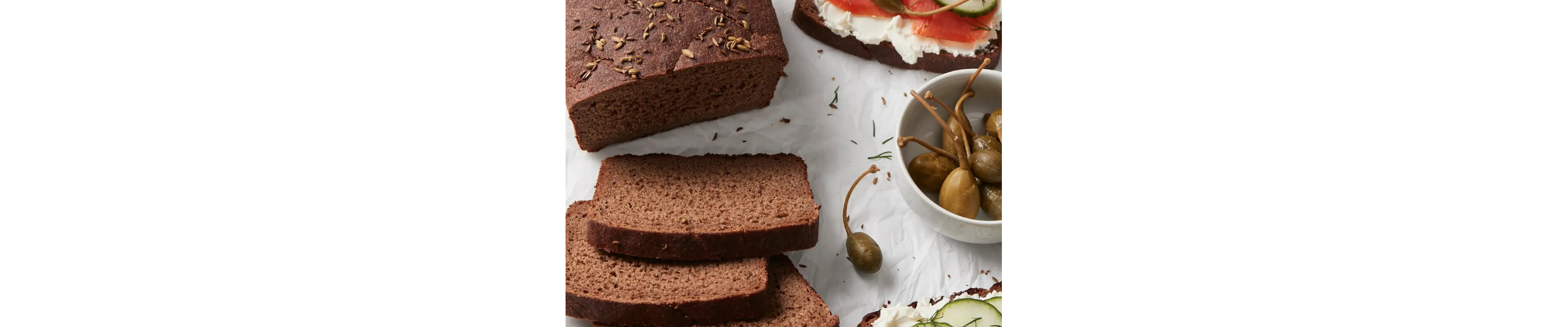 Pumpernickel loaf next to a bowl of olives