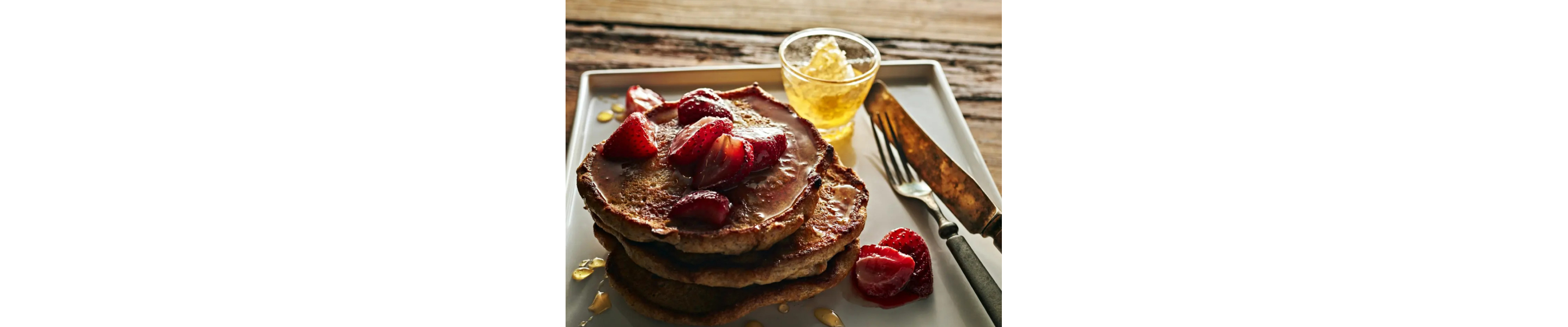 Lemon ricotta rye pancakes topped with sliced strawberries