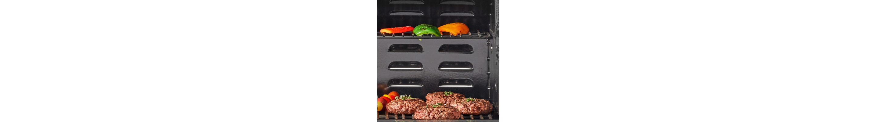 Ground meat patties on grill with grilled peppers