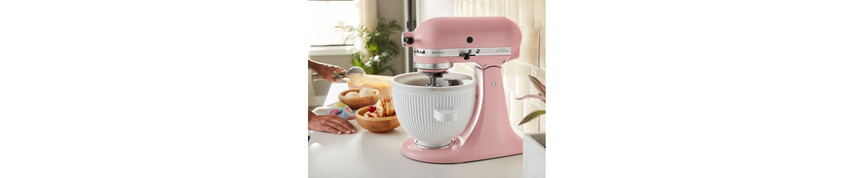 A KitchenAid® stand mixer on a countertop beside bowls of ice cream