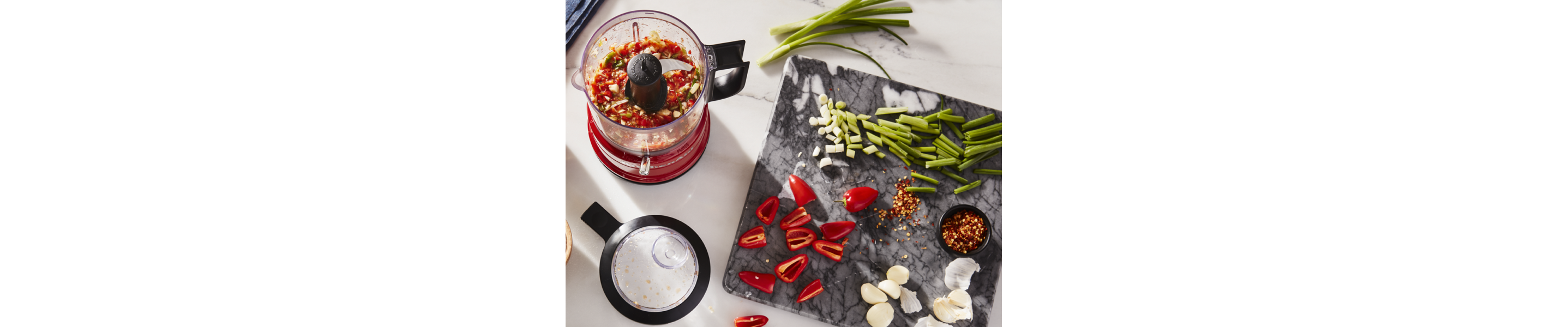 A KitchenAid® food chopper with assorted vegetables nearby.