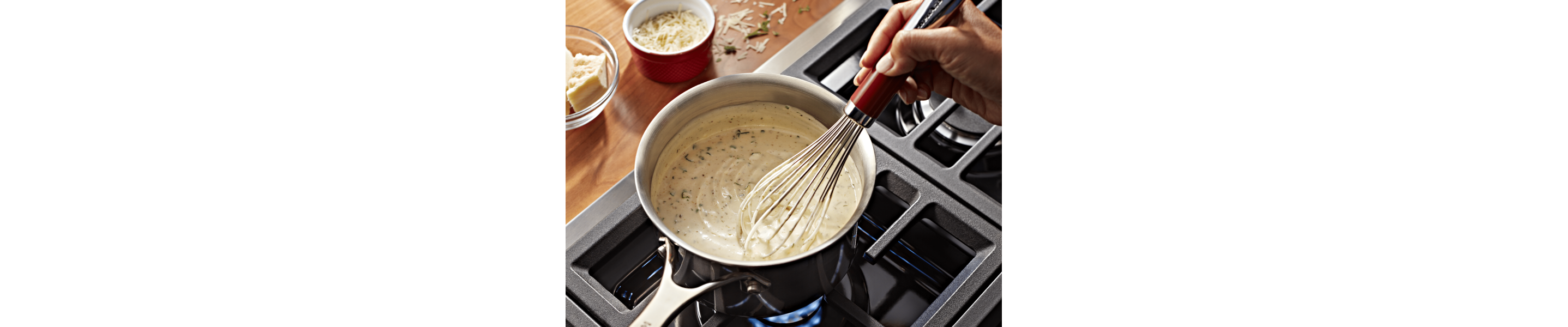 A person stirring homemade vegan queso on the stove.