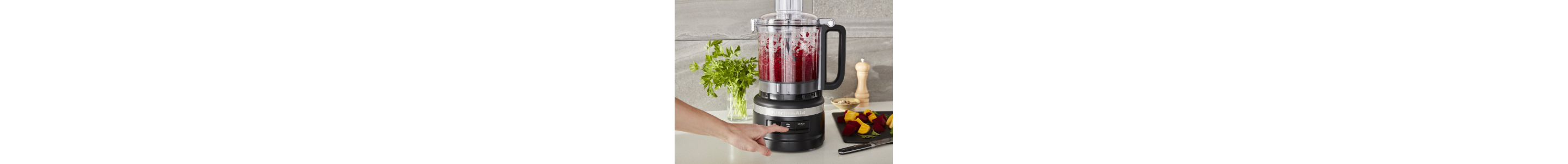 Woman mincing ingredients in a KitchenAid® food processor.