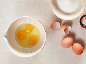 Three eggs broken into a measuring cup