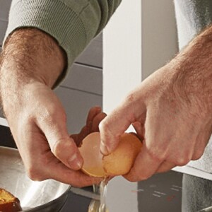 A person cracking an egg