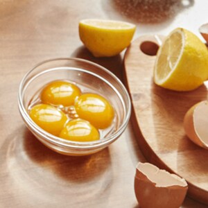 Multiple egg yolks shown in a small glass bowl