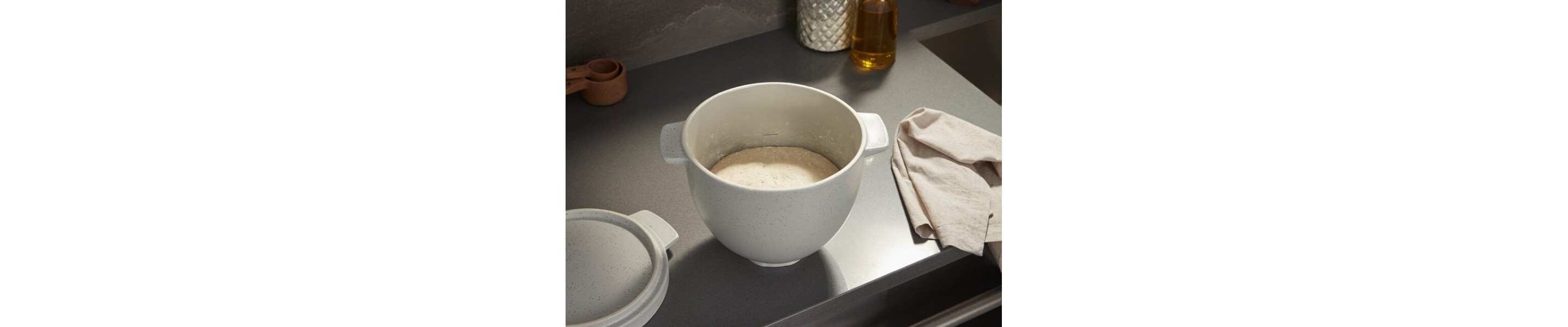Bread dough proofing in a bread bowl on a countertop