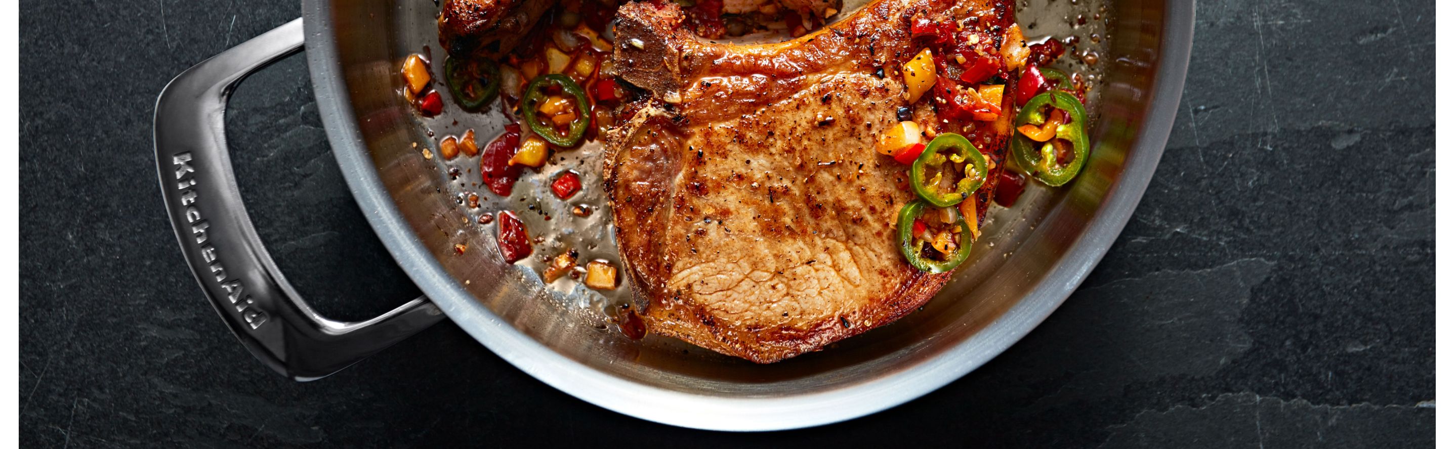 Steak in a KitchenAid® pan with various garnishes