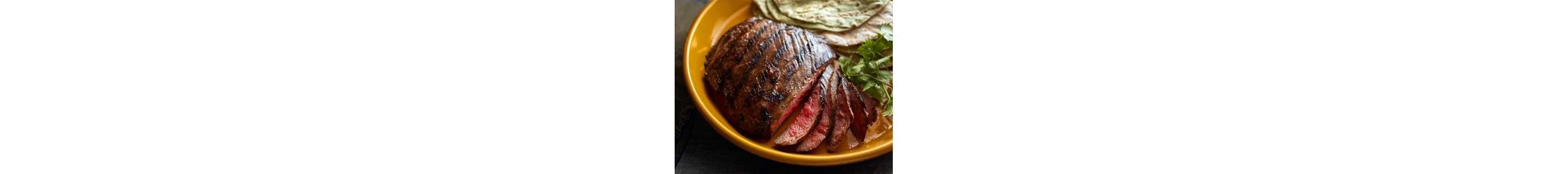 Sliced steak served on a plate with various sides