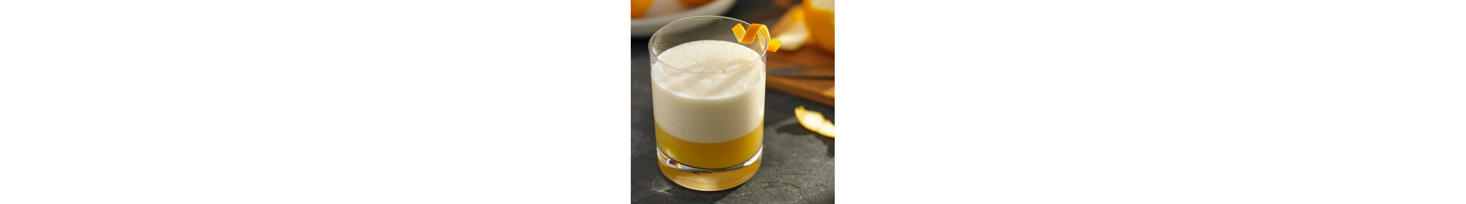 A glass of an orange whiskey cocktail