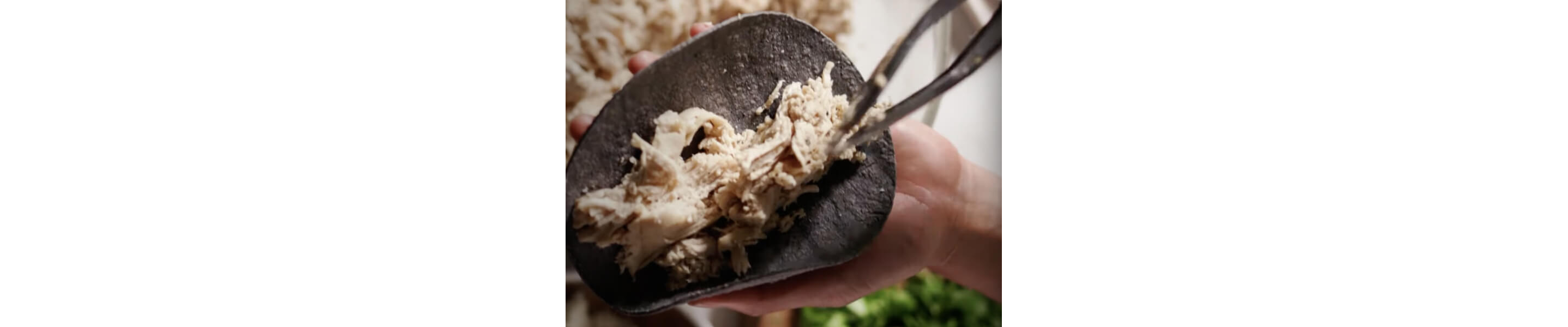 Shredded chicken on a tortilla.