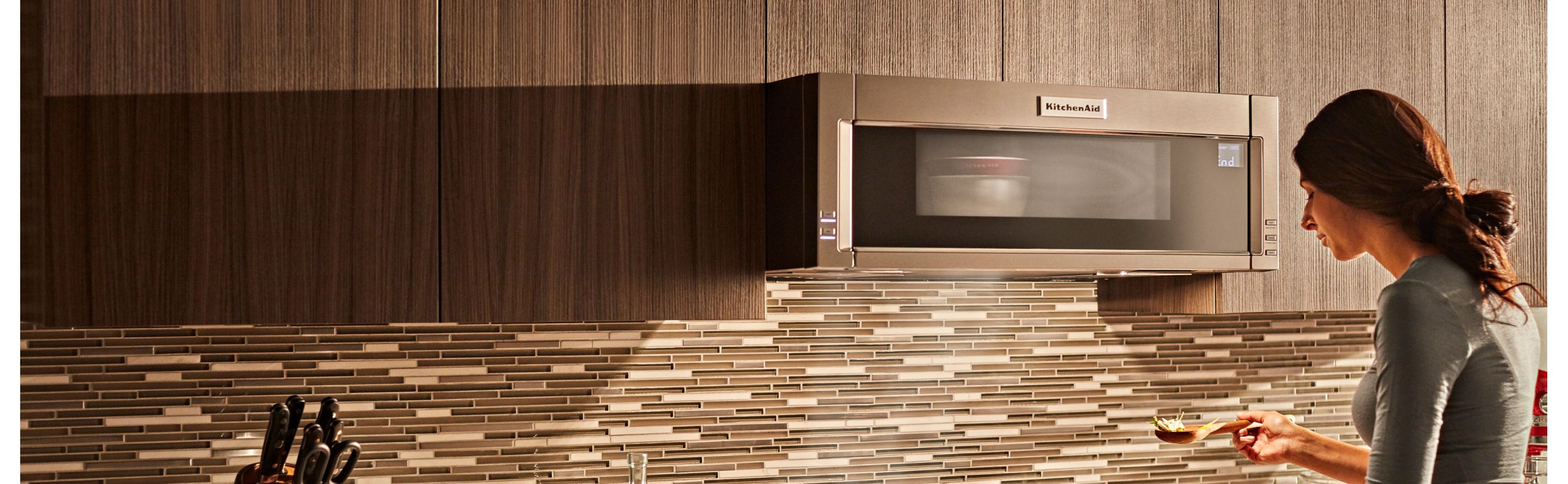 Person in front of a built-in KitchenAid® microwave