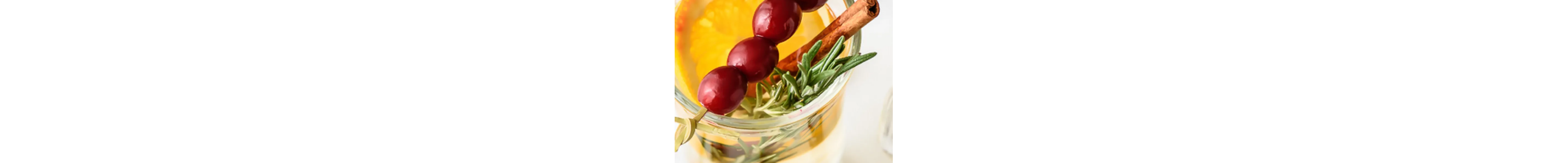Drink garnished with cranberries, cinnamon and fresh rosemary