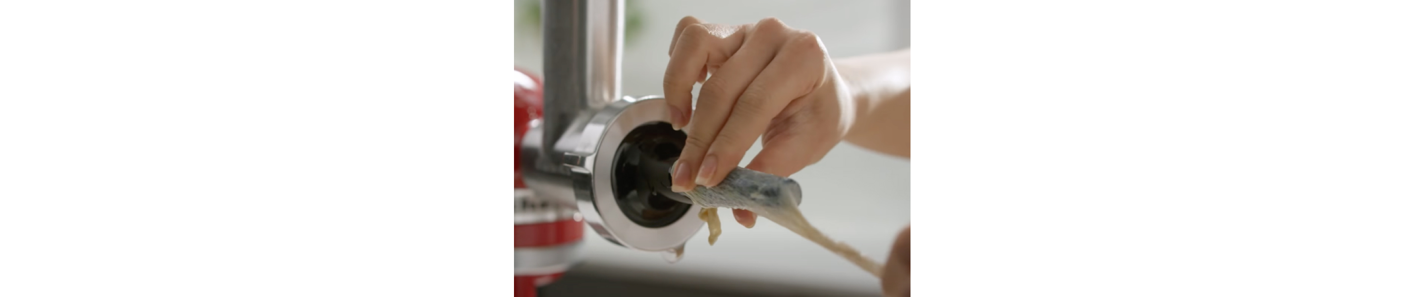 Person adding casing to the sausage stuffer tube