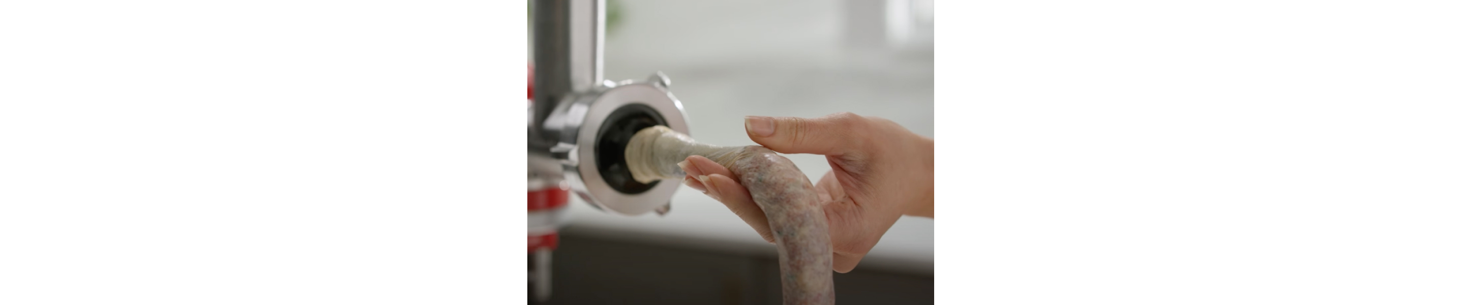 Person feeding ground meat into the casing