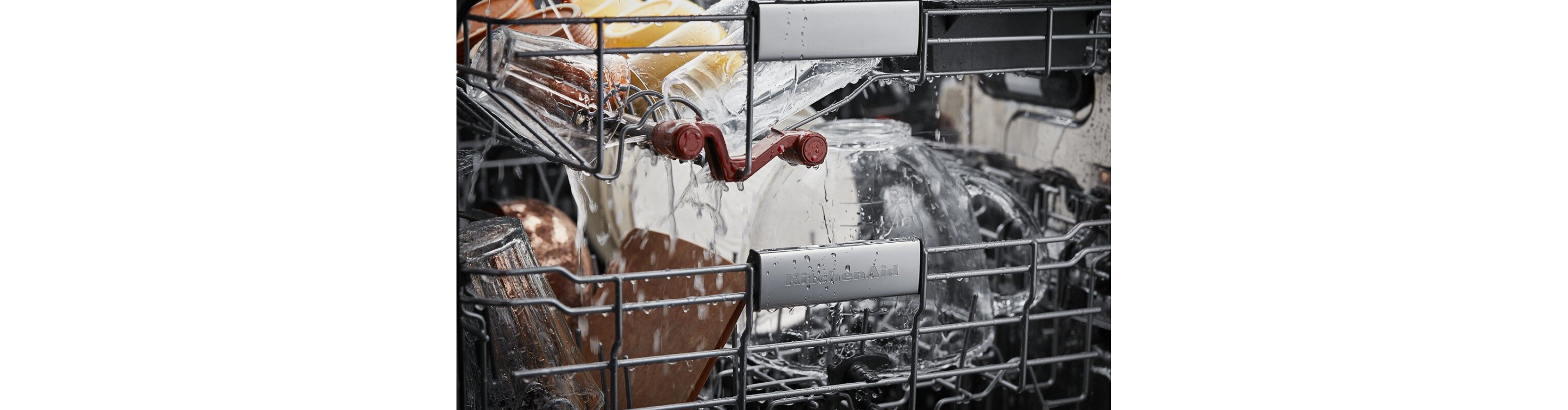 Closeup of the inside of KitchenAid® dishwasher with water spraying on the dishes