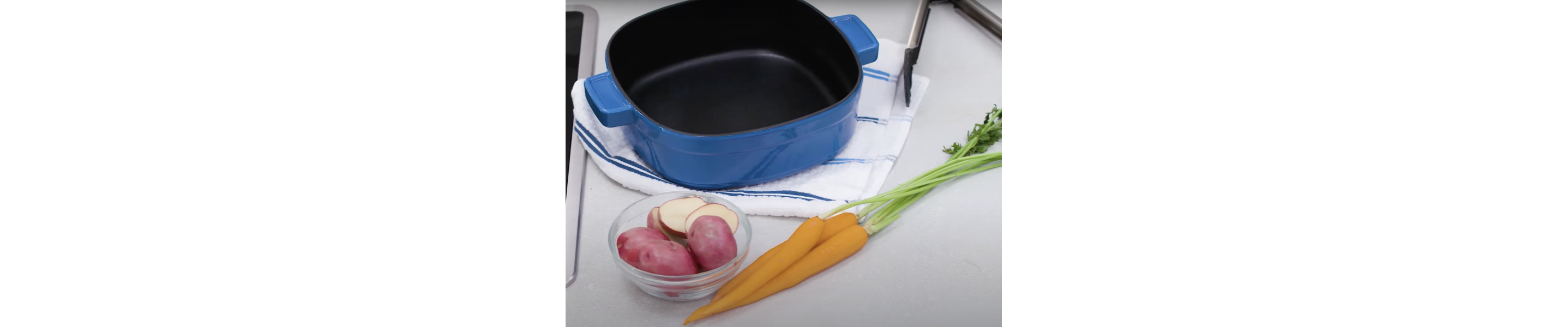 Blue dutch oven next to vegetables on a countertop
