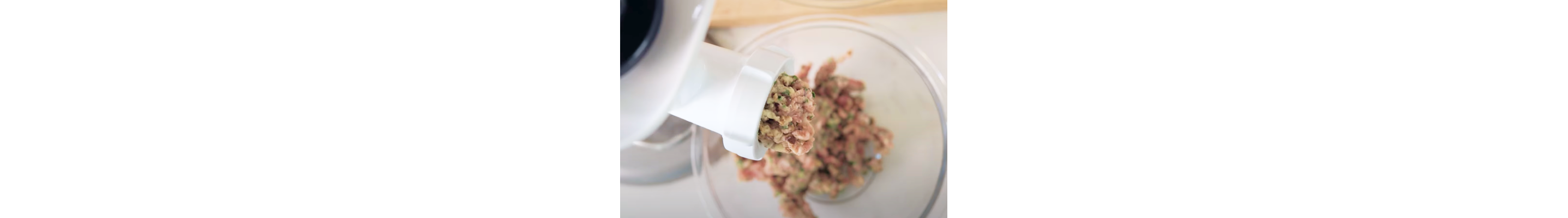 Close-up of seasoned ground beef moving through meat grinder
