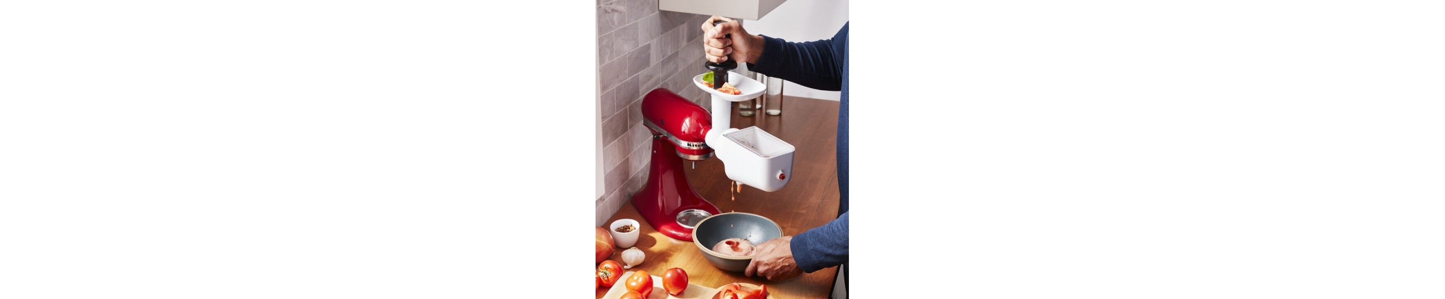 Person feeding food through meat grinder attachment with food pusher