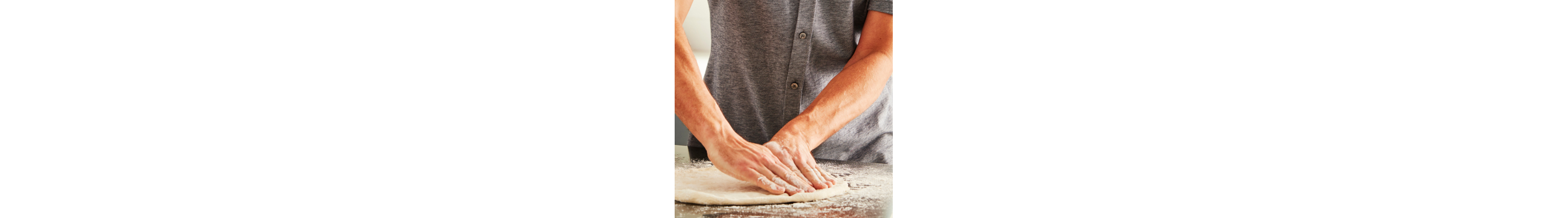 Close-up of Maker hands flattening a round of pizza dough